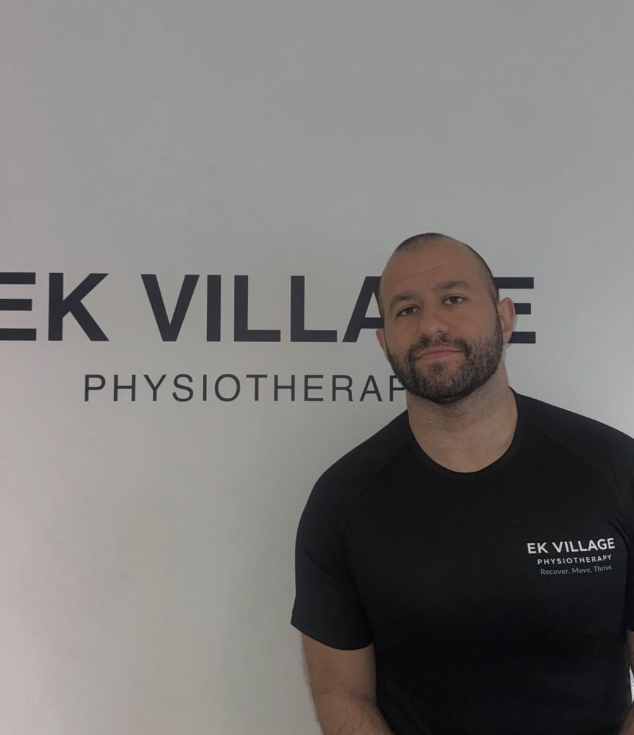 Nial Madani in the clinic, wearing an EK Village Physiotherapy shirt