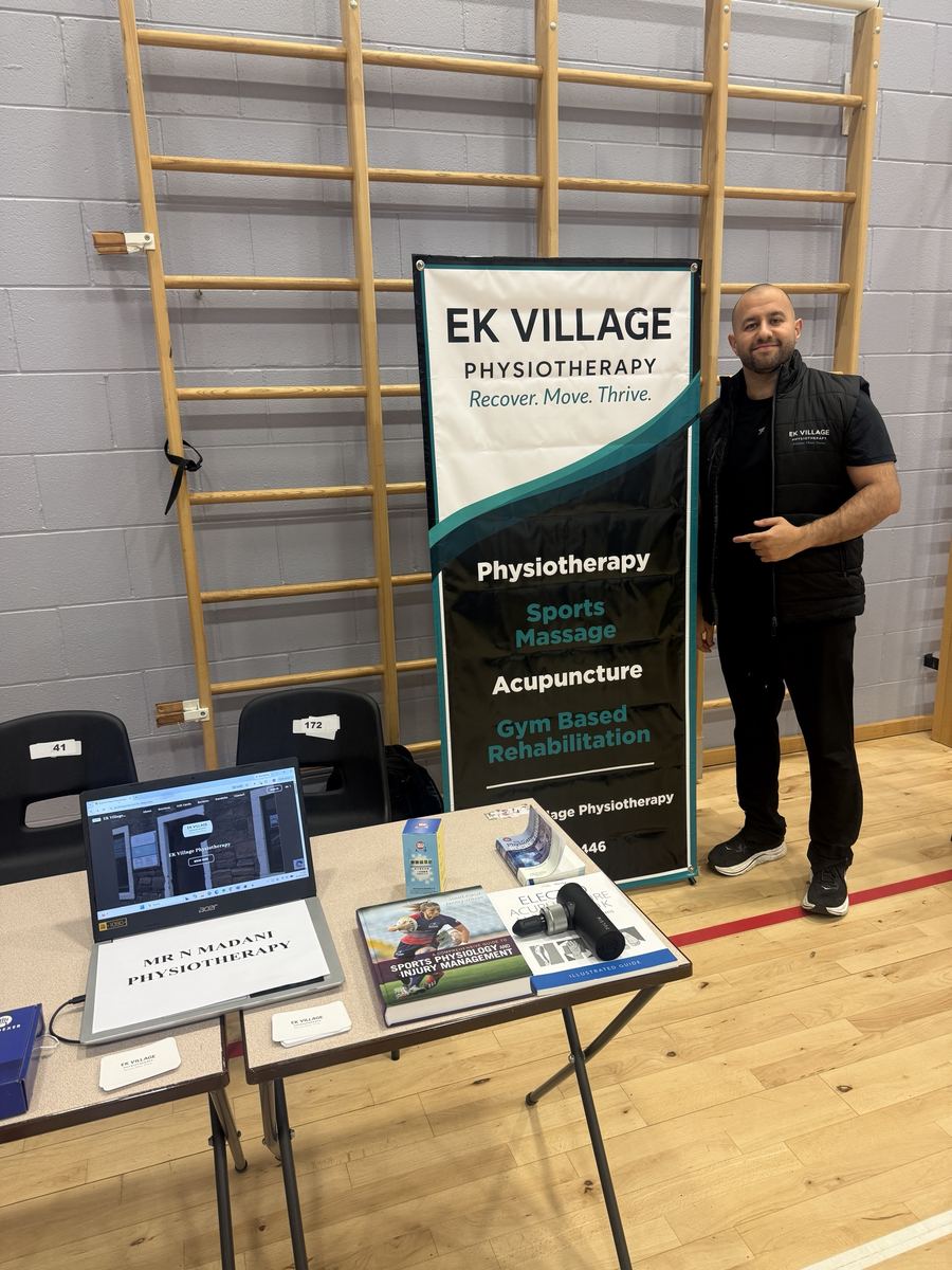 Nial Madani beside the EK Village Physiotherapy banner